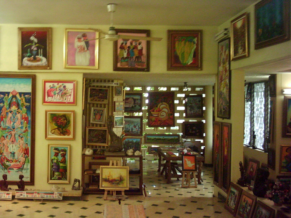 Inside the Rainbow Art Display: rooms hung floor to ceiling with framed Haitian paintings